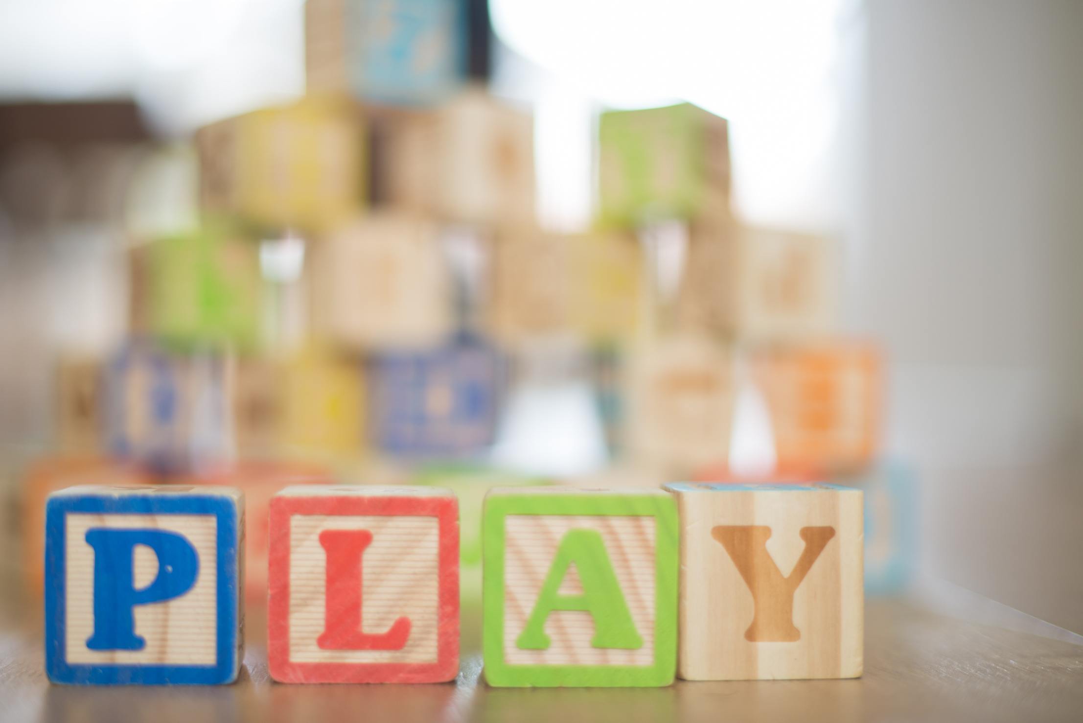 Photo of colorful wooden blocks that spell out play.