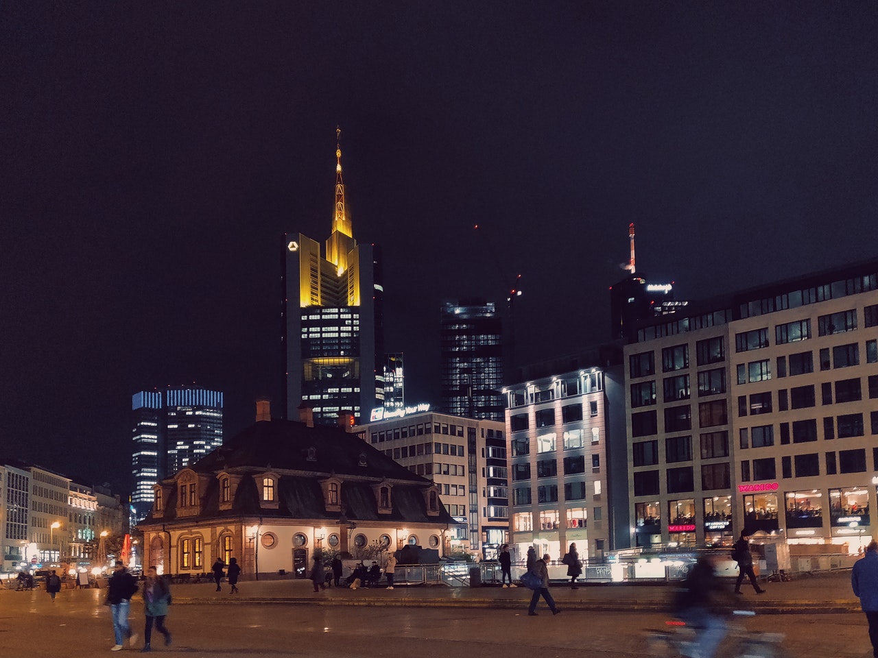 Photo of people walking on a busy city street in the evening.