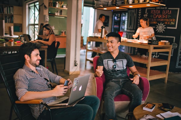 Two co-workers talking and practicing the time management technique of taking a break to socialize. 