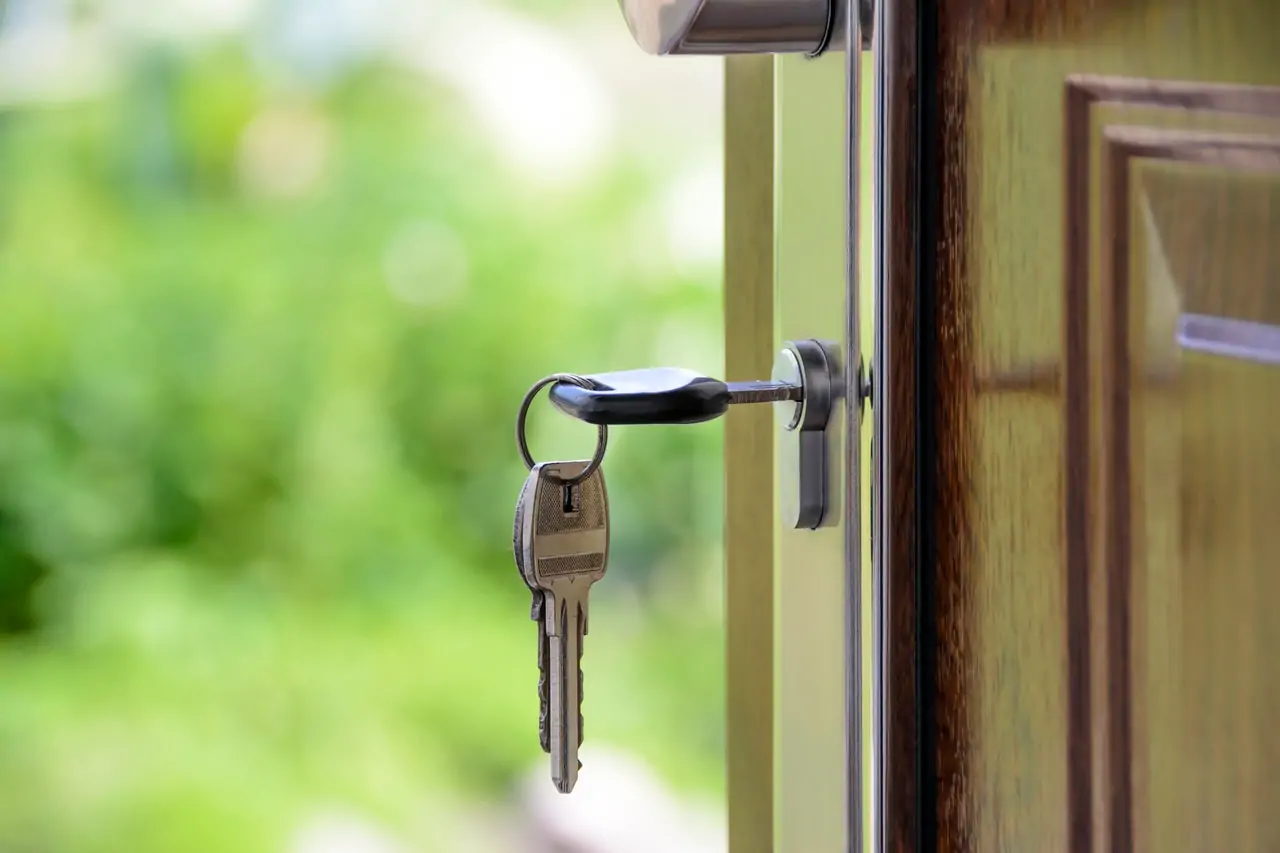 Photo of keys opening the door to a house. The agent sold the house with the help of her real estate virtual assistant. 